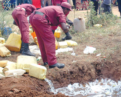 Local Defence Unit personnel destroy illicit brew in a past community policing exercise. File.