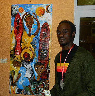 Innocent Buregeya poses next to one of his art works.