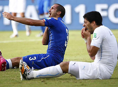 Down they go: Both men fell to the ground, with Chiellini clutching his shoulder and Suarez holding his teeth. Net photo