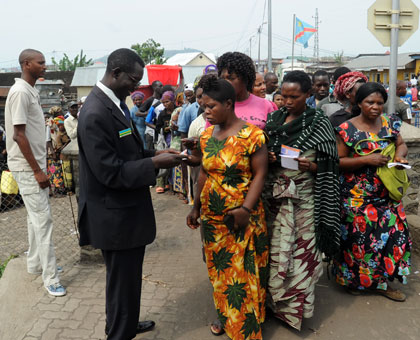 Rwandan immigration officials examine documents of travellers crossing from DR Congo into the country at Rubavu border. John Mbanda.
