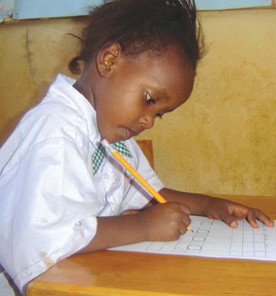 A child does homework on her own. Parental involvement is important but should be all about helping the child achieve real learning. / Timothy Kisambira