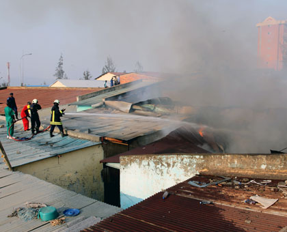 Police fire fighters try to contain the blaze from the rooftop of Quartier Matheus building yesterday. (John Mbanda)