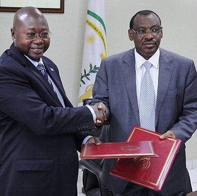 UN resident coordinator Lamin Manneh (L) and Finance Minister Claver Gatete pose for cameras after signing a Rwf19 billion financial support on Tuesday. John Mbanda.