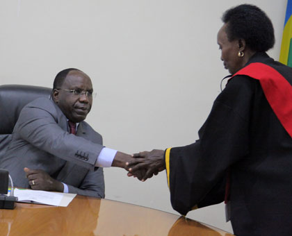 Prime Minister Pierre Damien Habumuremyi (L) congratulates Mukarugambwa Mukunzi, one of the prosecutors sworn in yesterday. John Mbanda.