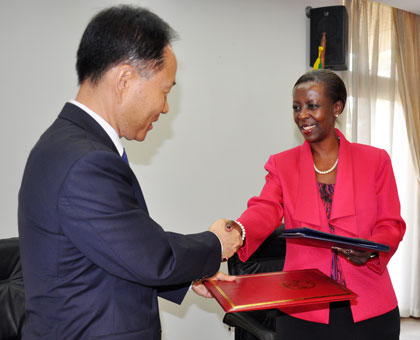 Minister Mushikiwabo (R) and Amb. Hwang exchange paper work after signing the deal in Kigali yesterday. Courtesy.