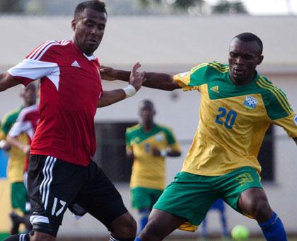 Striker Jacques Tuyisenge (R) seen against a defender from Libya in a past qualifying match scored the lone goal against Gabon in yesterday's friendly match held at Kigali Regional....