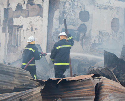 Police fire fighters battle the fire that gutted the grain mill in Gikondo yesterday. Timothy Kisambira.