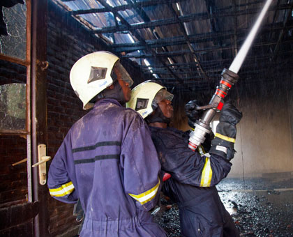 Police fire fighters struggle to put out the fire. Timothy Kisambira.