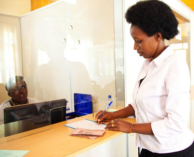 A teacher banking money at Umwalimu Sacco branch. T.Kisambira.  