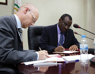 Molander (left) and Gatete sign the funding deal last week.  T. Kisambira