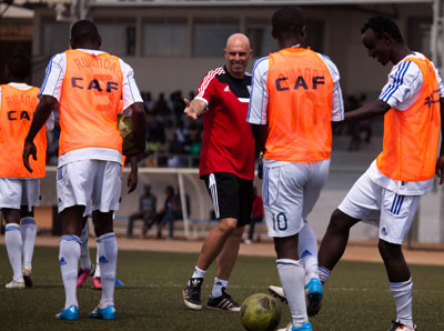 Coach Stephen Constantine shares a light moment with his players during a previous training session.  T. Kisambira