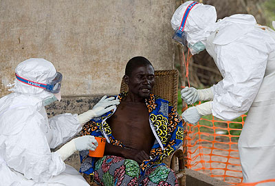 Nurses comfort a patient who has been diagnised with the Ebola virus. File.  