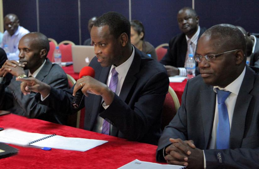 Inspector General of Courts Franu00c3u00a7ois-Ru00c3u00a9gis Rukundakuvuga (C) speaks at the meeting as High Court president Charles Kaliwabo (L) and Apollinaire Mupiganyi look on. (John Mbanda)