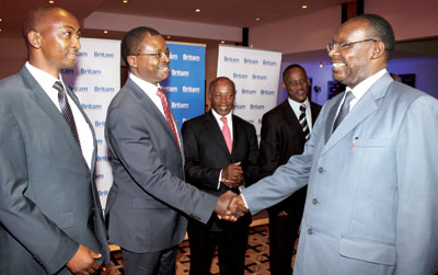 Britamu2019s Stephen Wandera (centre) greets trade minister Francois Kanimba (right) at the launch as Britam Rwanda general manager Reuben Kibiru (left) and other officials look on.  Ben Gasore.