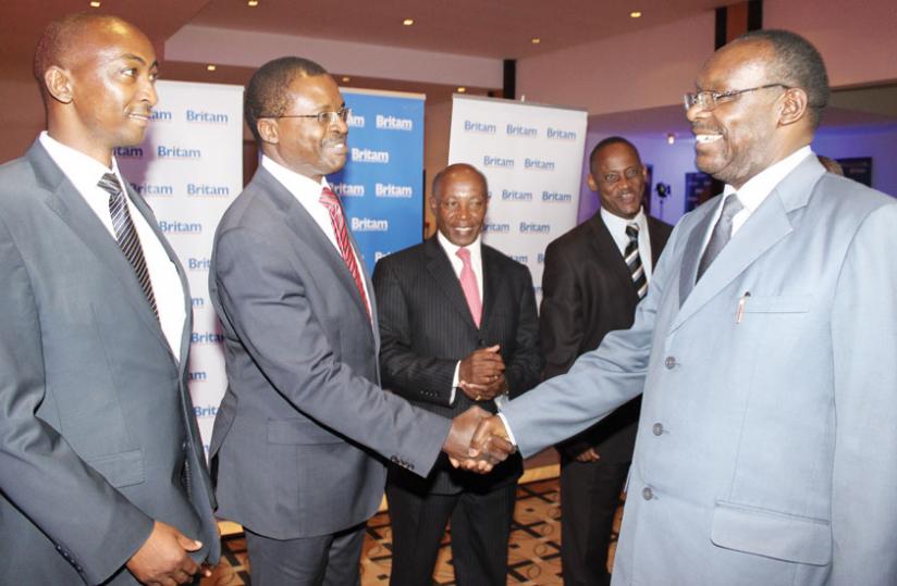 Britamu00e2u20acu2122s Stephen Wandera (centre) greets trade Minister Francois Kanimba (right) at the launch as Britam Rwanda general manager Reuben Kibiru (left) and other officials look on. (Ben Gasore)