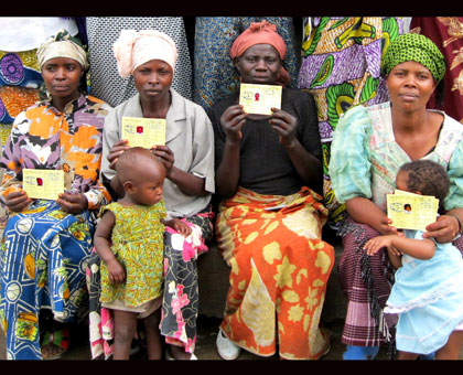 Mothers  pose in a group photo with their Mutuelle de Sante cards. File. 