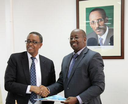 Former Infrastructure Minister Prof. Silas Lwakabamba (L) hands over to his successor Minister James Musoni yesterday. Lwakabamba is the new education minister. (John Mbanda)