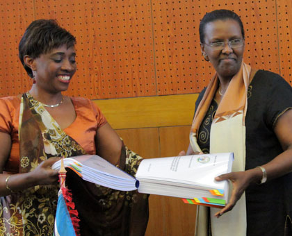Rugwabiza (right) receives documents from her predecessor Muhongayire, at the handover yesterday. (John Mbanda)