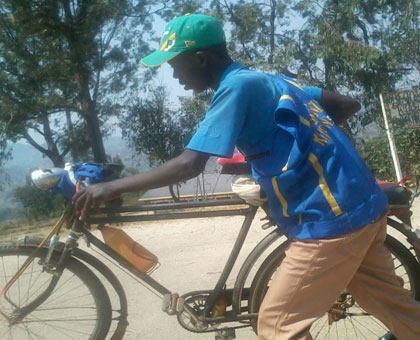 Dusengimana pushes his bicycle on the Bandagure-Gafumba murram road, in Rusatira Sector, Huye District, on Tuesday. (JP Bucyensenge)