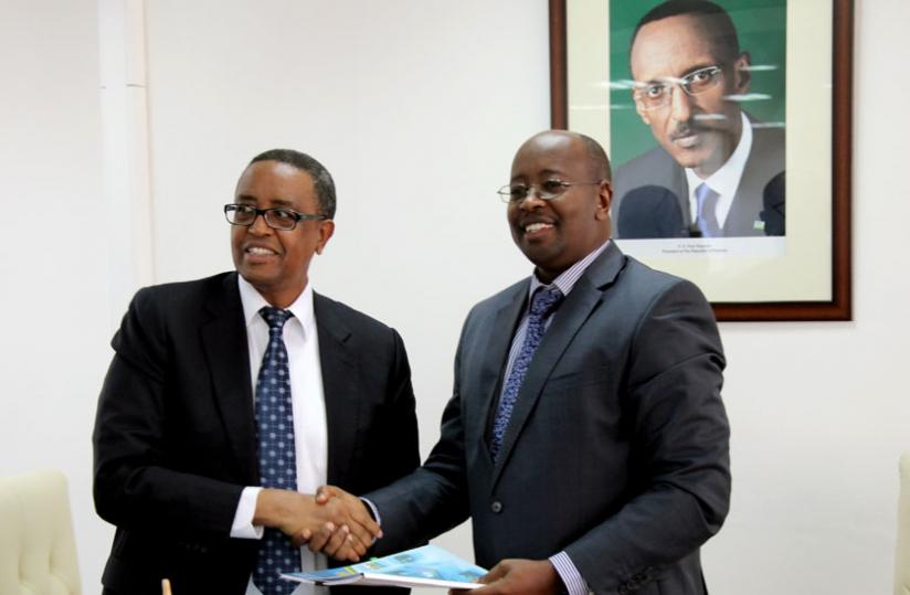 Former Infrastructure Minister Prof. Silas Lwakabamba (L) hands over to his successor Minister James Musoni yesterday. Lwakabamba is the new education minister.  (John Mbanda) rn