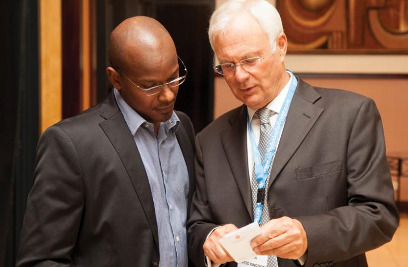 Church (left) chats with Moses Gatama Kiiza of Equity Juris Chambers during the retreat at the Serena Kigali Hotel. The global law firm has expanded its operations in East Africa. (Timothy Kisambira)