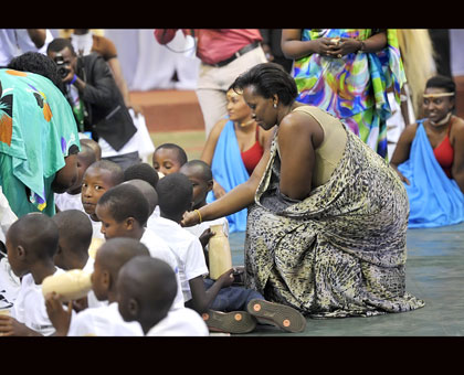 The First Lady, Jeannette Kagame, serves milk to children at the closure of the Umuganura festivities at Petit Stade, Kigali, yesterday. Courtesy. 