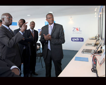Murekezi talks to Eng. Sam Nkusi (right), the Liquid Telecom boss, during a visit to the companyu2019s stand at the expo yesterday. John Mbanda. 