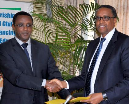 Dr Vincent Biruta (L) hands over to Silas Lwakabamba. (Courtesy)