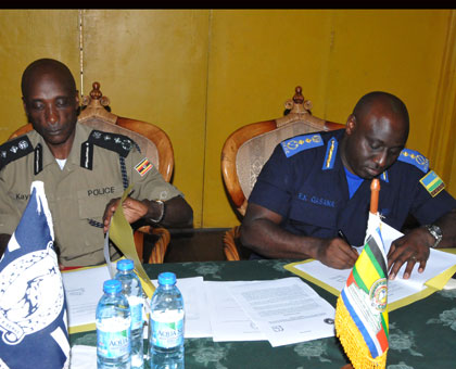 Ugandau2019s Inspector General of Police Kale Kayihura (L), and his Rwandan counterpart Emmanuel. K. Gasana ink a deal during the meeting in the Ugandan South Western town of Kabale yesterday. Courtesy .