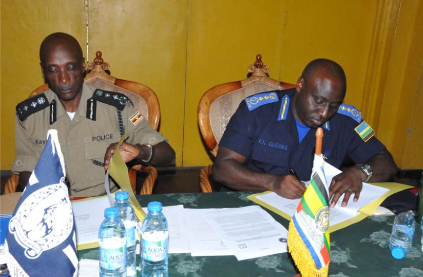Ugandau00e2u20acu2122s Inspector General of Police Kale Kayihura (L), and his Rwandan counterpart Emmanuel. K. Gasana ink a deal during the meeting in the Ugandan South Western town of Kabale yesterday. (Courtesy)