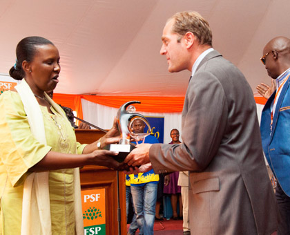 The Minister for East African Community Affairs, Amb. Valentine Rugwabiza (L), hands over the overall best exhibitor award of the 17th Rwanda Trade Fair to Jan Van Velzem, the marketing manager of Bralirwa. (Timothy Kisambira) 