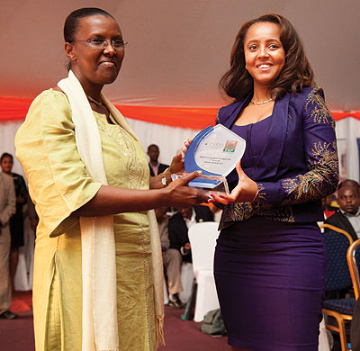 Made in Rwanda Limitedu2019s Scorpio Ramazani Kourey (right) receives the third-best exhibitor award from Amb Rugwabiza at the closure of the 17th Rwanda International Trade Fair on Wednesday. (T. Kisambira)