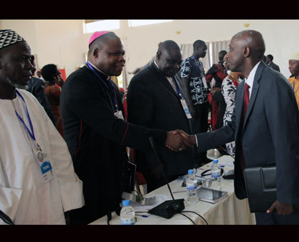 Local Government minister Francis Kaboneka (R) greets Archbishop Dieudonnu00e9 Nzapalainga of Bangui, Central African Republic, at the opening of the Global Peacebuilders Conference in Kigali yesterday. (John Mbanda)