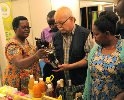 Christine Murebwayire (L), a local exporter, explains about her banana wine at the National Exportersu2019 Forum in Kigali yesterday. (John Mbanda)