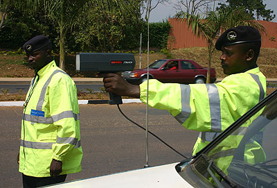 A Traffic policeman uses a speed gun to monitor traffic on a highway. (John Mbanda)