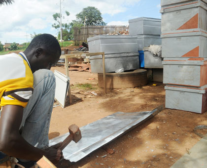 A youth making metallic boxes at a workshop in Gajingiro, Nyarugege District. Timothy Kisambira. 