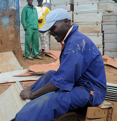 A young man fabricates metal boxes in an open workshop in Gikondo. John Mbanda.
