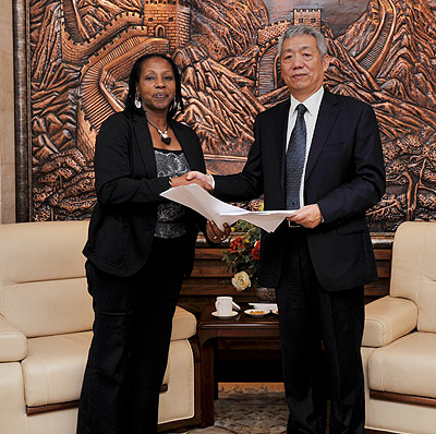 Amb. Shen Yongxiang of the Peopleu2019s Republic of China (right) and Radegonde Ndejuru, Director General, Imbuto Foundation, exchange documents at the Chinese Embassy yesterday. Courtesy.
