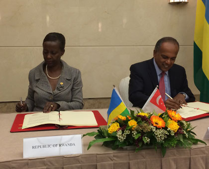 Mushikiwabo (L) and her Singaporean counterpart Shanmugan sign the deal. (Courtesy)
