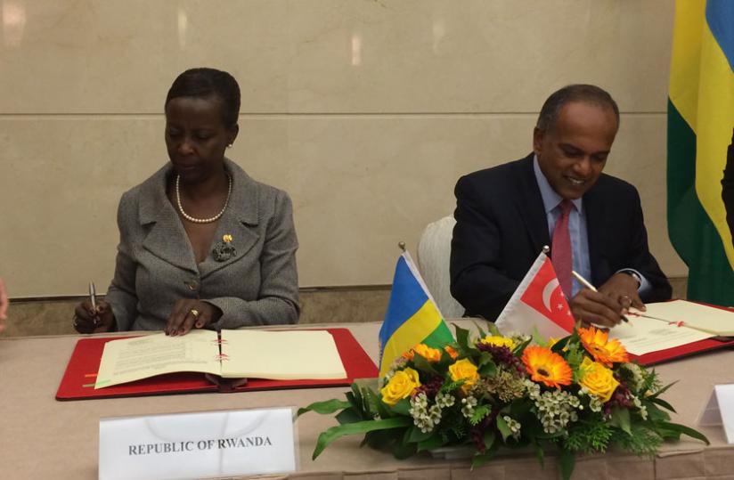 Mushikiwabo (L) and her Singaporean counterpart Shanmugan sign the deal. (Courtesy)