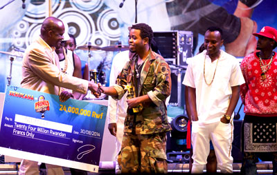 Jay Polly receives a dummy cheque worth Rwf24 million from the Culture and Sports Minister, Joseph Habineza.