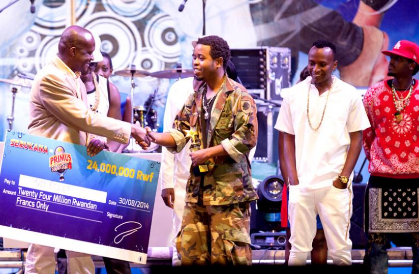 Jay Polly receives a dummy cheque worth Rwf24 million from the Culture and Sports Minister, Joseph Habineza.