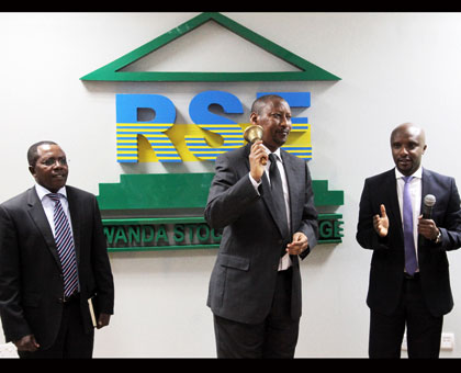 Central bank governor John Rwagombwa (C) rings the bell to launch of the trading of the bonds yesterday as executive director CMA Robert Mathu (L) and RSE chief executive Celestin Rwabukumba look on. (John Mbanda)