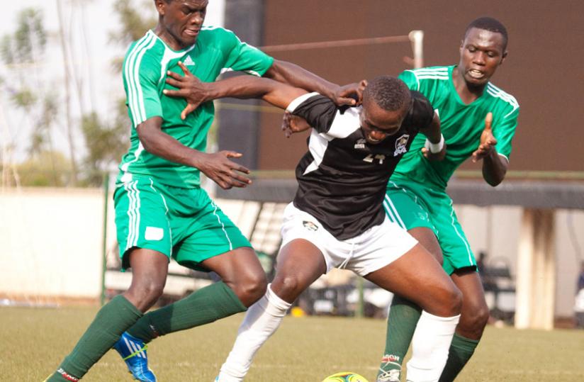 APR FC's Michel Fils Ndahinduka shielding the ball from Kiyovu Sports defenders. APR FC won the league last season for their record-extending 14th title. (Timothy Kisambira)