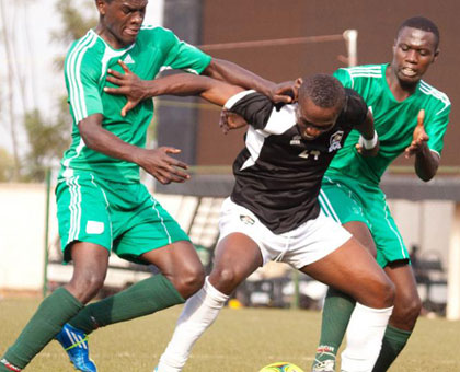 APR FC's Michel Fils Ndahinduka shielding the ball from Kiyovu Sports defenders. APR FC won the league last season for their record-extending 14th title. (Timothy Kisambira)
