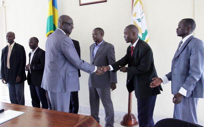 Minister Busingye congratulates court bailiffs and notaries after a  swearing in ceremony in April this year. (Net photo)