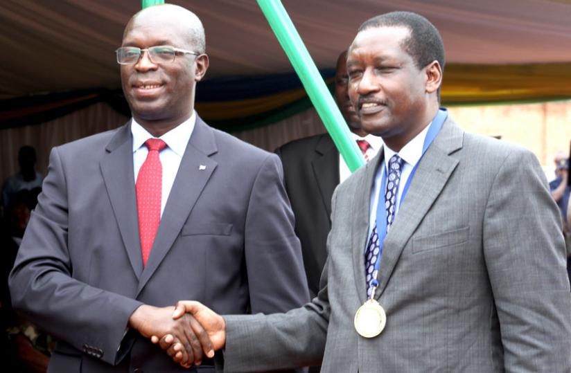Murekezi (L) congratulates Bank of Kigali chief executive officer James Gatera, upon the banku00e2u20acu2122s being named taxpayer of the year. (Courtesy)