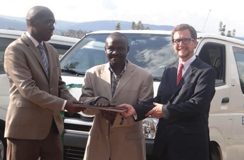 Callixte Kalisa (left) and sbficu00e2u20acu2122s Thomas Konitzer (right) hand over partnership documents and car keys to Bahizi (middle). (Peterson Tumwebaze)    