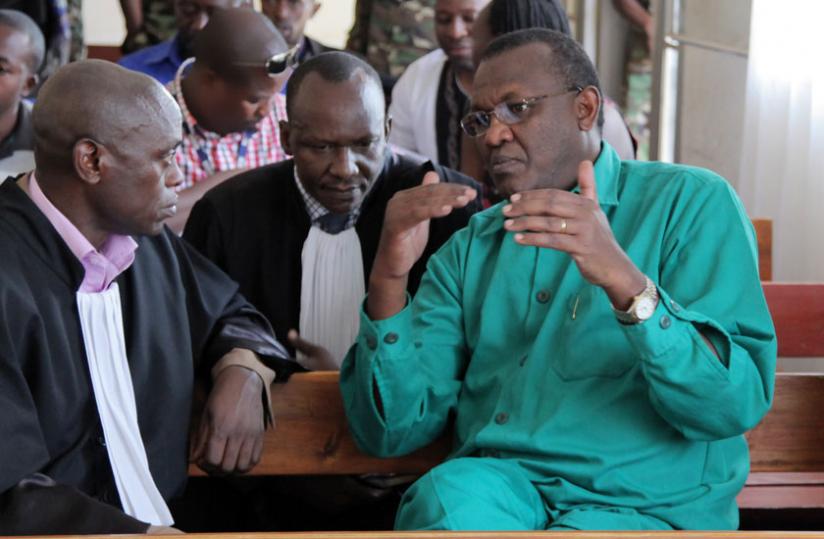 Rusagara (R) talks to his lawyers Godfrey Butare (L) and Emmanuel Ntamabara in a past hearing. (File)