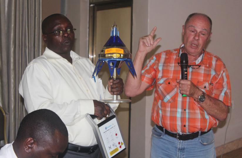 Richard Houben, Director of SONATUBES demonstrates to participants how a lightning rod operates as Kalimunda Fidu00c3u00a8le, SONATUBES Electricom MD holds the equipment at the meeting yesterday. (Courtesy)